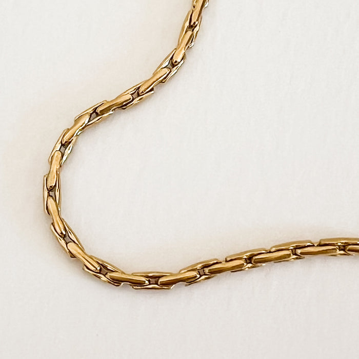 Close up of the curvilinear box chain link on the Elin necklace. Gold plated, hypoallergenic stainless steel. Water, sweat and tarnish resistant.