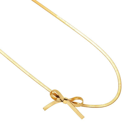 Gold snake chain necklace with a bow that hangs to the side. Measures 14" length with 2" extender.