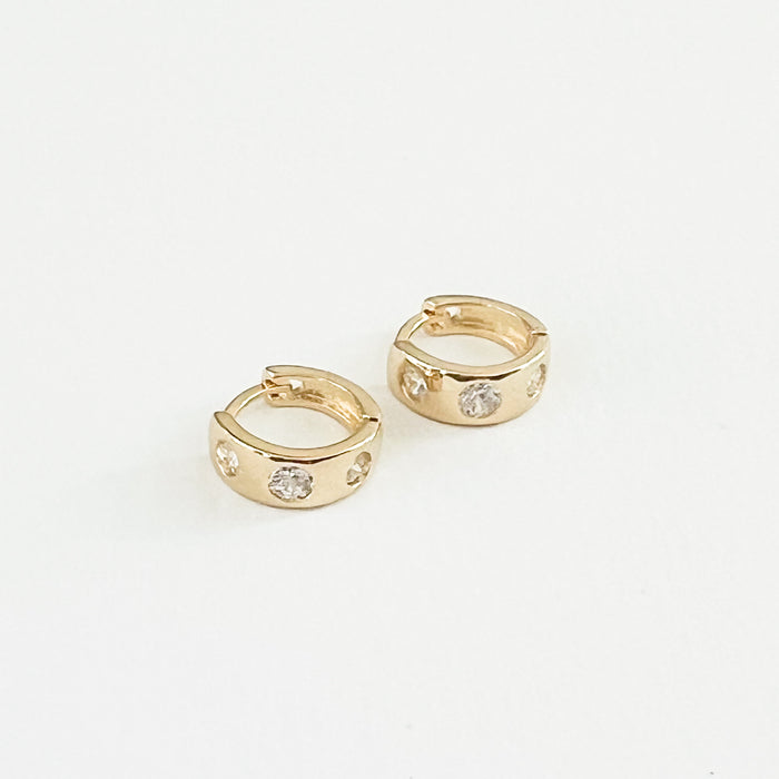 Pair of 18K gold filled Chloe huggie hoop earrings inlaid with clear CZ crystals. 1/2" diameter, 3/8" thick.