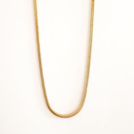 The Lyra necklace by Ellie Vail. 14" golden snake chain necklace with a lobster claw clasp. Water, sweat and tarnish resistant jewelry. Made of hypoallergenic stainless steel with gold plating.