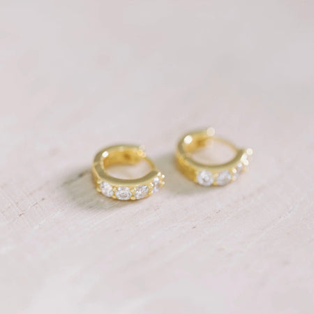 Crystal huggie earrings made of 18k gold vermeil with inset crystals. 3/8" diameter.