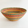 Multi-color stripe Calypso basket/bowl. Handwoven bowl shaped basket in stripes of orange, coral, turquoise and natural abaca. Measures 18” diameter, 8” height.