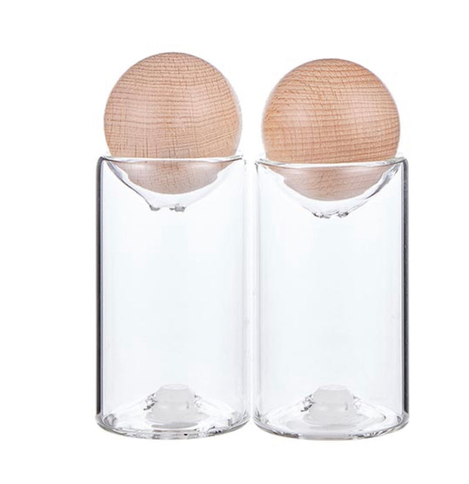 Melbourne glass salt + pepper shakers with natural mango wood stopper. Set of two. Measures 3.25" H x 1.75" diameter. Hand wash only.