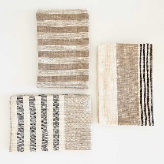 Set of 3 Mesa stripe hand towels in cream, tan and black. Three eclectic stripe towels made of 100% cotton hopsack. Measures 28" x 18'.