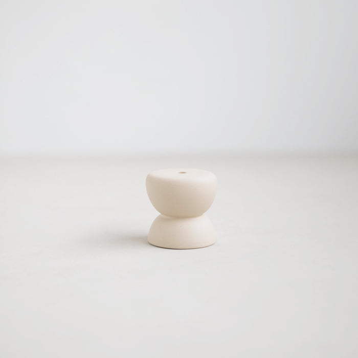 Gem ceramic candle holder, part of the Pebbles collection designed to hold the slim Wish Candles (sold separately). Soft organic form inspired by beach pebbles formed in ceramic with a matte white glaze. 2" diameter x 1.25"tall. 