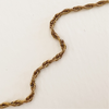 Close up detail of the twisted rope chain of the Gia Necklace. 26" length, perfect for layering charms. Made of gold plated hypoallergenic stainless steel. Water, sweat and tarnish resistant.