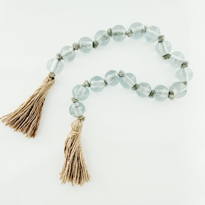 34 inch decorative blue glass bead garland with natural jute tassels on each end. Glass beads measure 1".