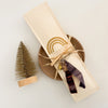 Package of 12 hand rolled Grey Copal incense sticks with a taupe ceramic incense dish. Incense is packaged in a hand crafted paper envelope with a hand dyed plum ribbon and brass charm.