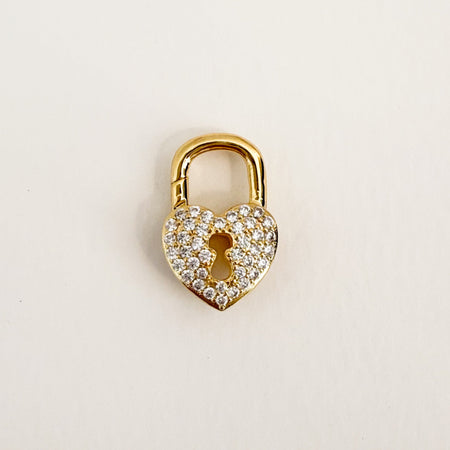 Heart shaped gold lock with clear CZ pave' on each side. Hinged carabiner lock is able to hold charms.