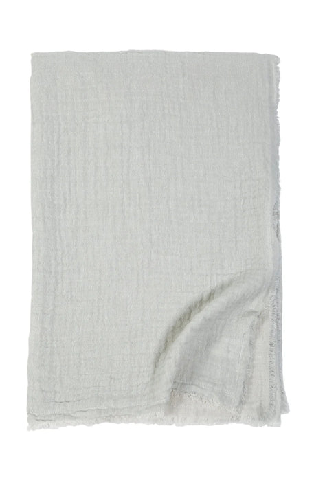 Hermosa gauze throw in ocean. A soft cotton linen blend woven in a gauzy double face weave with gently frayed edges. One side is ocean the other is cream. Measures 60 x 90 inches. 