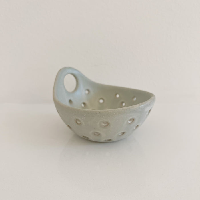 Small stoneware berry bowl in a pale matte grey glaze. Small round handle. Measures 5" diameter 3" high. Dishwasher safe.