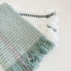 Set of 2 Rosemary waffle hand towels. Sage green towel with fine white and grey stripe with fringe ends. White waffle towel with sage green and grey stripe and fringe ends. Measures 28" x 18". 100% cotton,