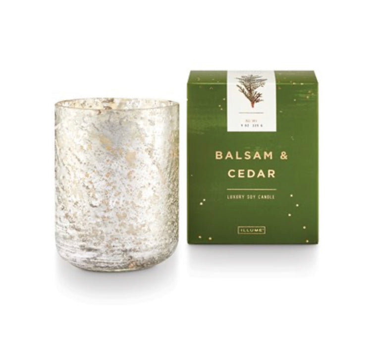 Boxed Balsam + Cedar holiday candle by Illume. Fragrance grounded in rich oak moss with a heart of fir needle, kissed with warm cinnamon. Luxury plant-based candle, clean burning and hand poured into a silver shimmer crackled glass vessel. 8.3oz/235g.