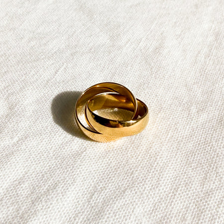 Interlocking gold band rings. Made of stainless steel with gold plating. Water, sweat and tarnish resistant.