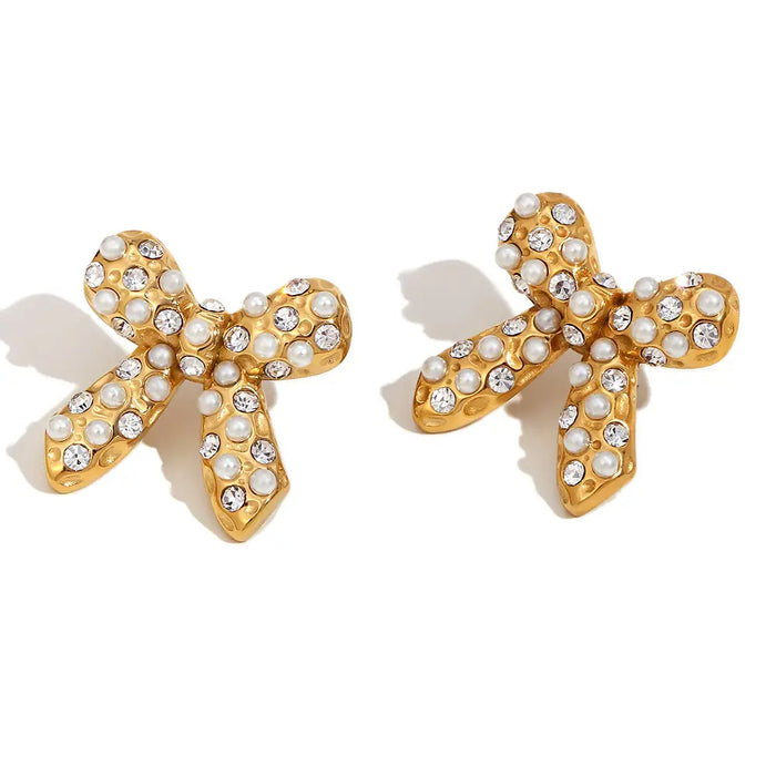Gold bow-shaped earrings with pearl and crystal cabochon . Measures 1" x 1".