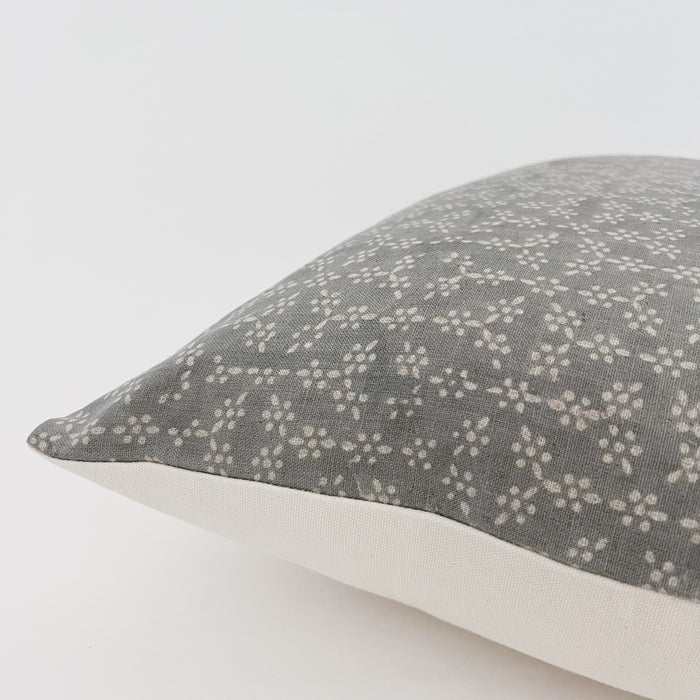 Side view of the Krishna pillow. Bohemian woodblock print in a blue-grey dotted floral pattern with a solid off white back. 20" square with down insert.