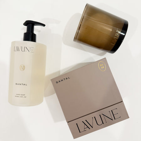 LAVUNE Santal fragrance collection. Candle in a smokey glass vessel with a taupe box and hand wash in a frosted bottle. Each sold separately.