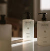 Bottles of LAVUNE Santal  hand soap on a counter with blurred background.