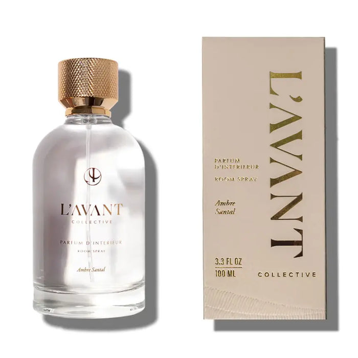 L'AVANT Ambre Santal room spray in clear glass bottle with gold lid and taupe packaging on a white background. 3.3 fl oz, 100ml.