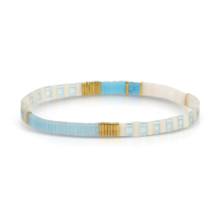Pale blue, turquoise, white and gold stretch bracelet made using flat, square "Tila" beads. One size fits most.