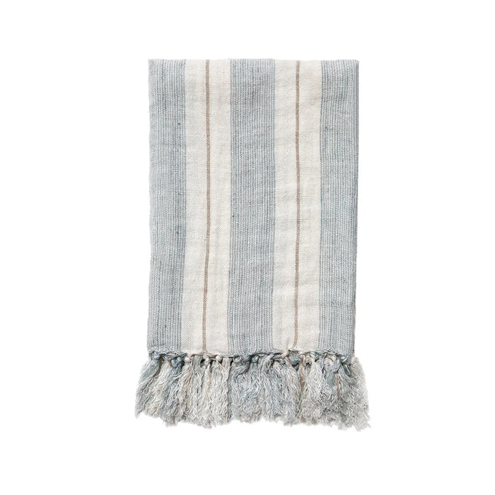 Laguna Throw by Pom Pom at Home. 100% heavy weight European linen. Woven in a soft white with ocean blue and sand stripes. Finished with  tassels on each end. Measures 50 x 70 inches