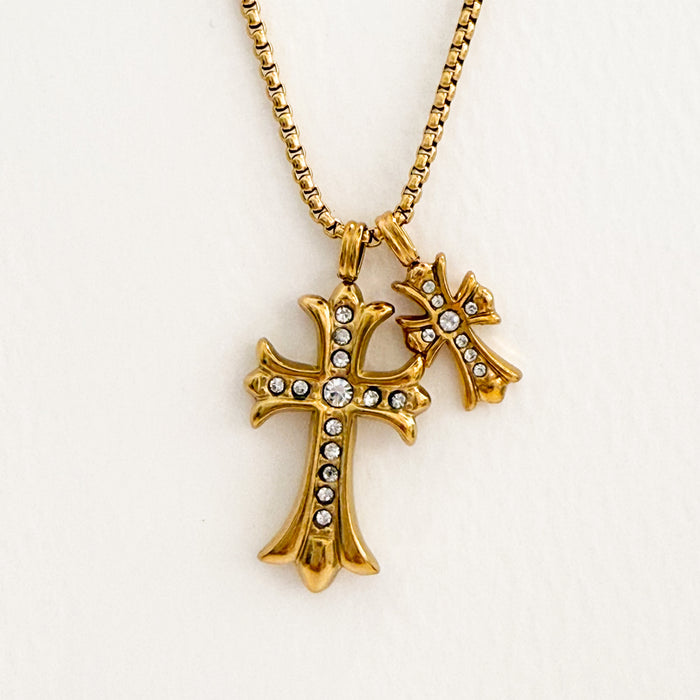 Two gold cross pendants adorned with clear CZ stones on a delicate gold box chain necklace. Cross height 1 1/8" and 5/8".