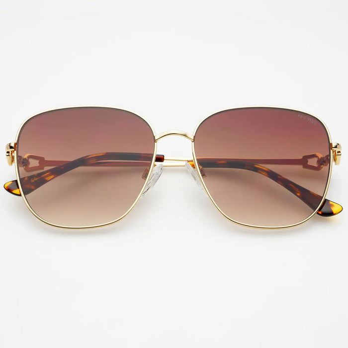 Sunglasses with gold frame and brown gradient lenses with acetate tortoise arms on a white background.