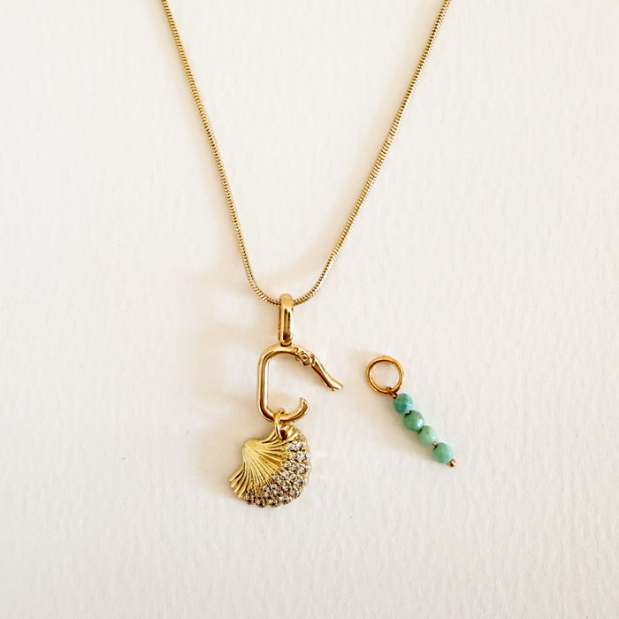 Delicate 20 inch gold filled snake chain necklace with a oval hinged carabiner and assortment of charms. Gold seashell charm and turquoise bead charms sold separately.