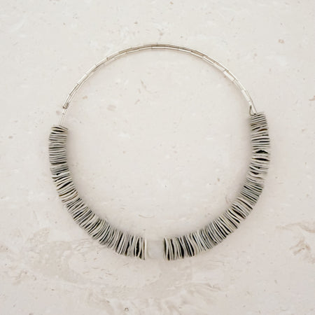 Flexible collar necklace strung with natural shell discs and centered with a chunky Moonstone. Flexible, fits most necks.