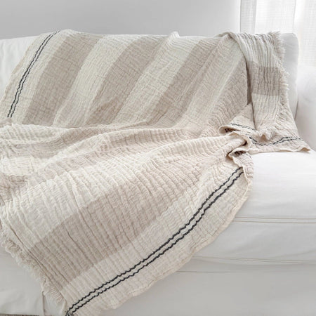Ivory and beige striped crinkled throw on a white sofa.