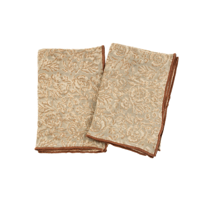Two folded grey and beige hand towels with floral block print designs and satin stitch hem.