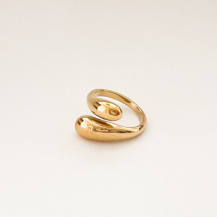 Mercer Wrap Ring. Curvy open ended ring with a sculptural silhouette that wraps around the finger. One size, adjust with a gentle squeeze. Fits up to a size 8 finger. Made of gold plated hypoallergenic stainless steel.