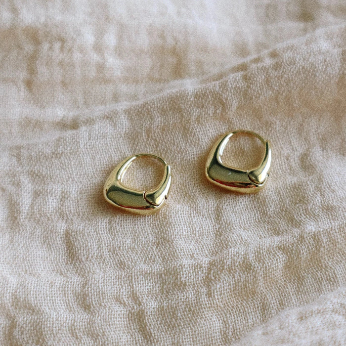 Pair of small gently rounded trapezoid shape hoop earrings. 14K gold plated over brass. 13.5 x 15mm.
