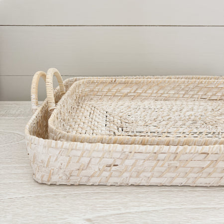 Montauk Trays. Set of 2 rectangular nesting trays woven in thin strips of dried bamboo with rattan handles. White washed for a clean minimal look. Small measures 16" x12" x 2.5" (4.75" including handle)
Large measures 17.5" x 13.75" x 2.75" (5" including handle)