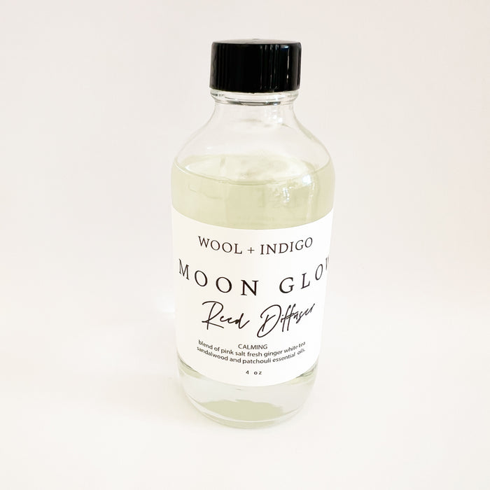 "Moon Glow" Fragrance Diffuser in a clear 4 oz. glass bottle with eight rattan reeds. Moon Glow is fragrance blend of Pink Salt, Ginger, Sandalwood and Patchouli essential oils. Blended in the USA using a zero VOC base, natural fragrances and essential oils.