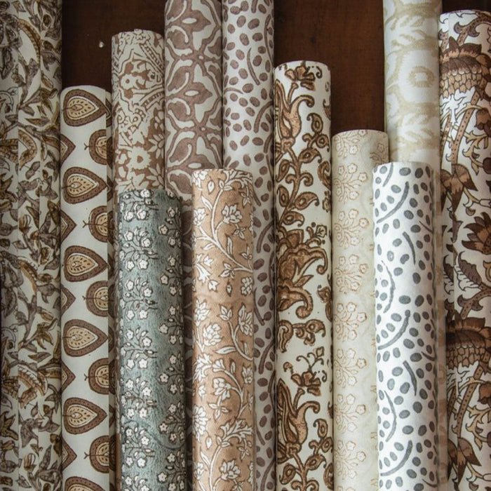 Collection of rolls of woodblock printed gift wrap in soft neutral colors. Each roll is a unique pattern. Each sold separately. 3 sheets per roll, 28" x 20"