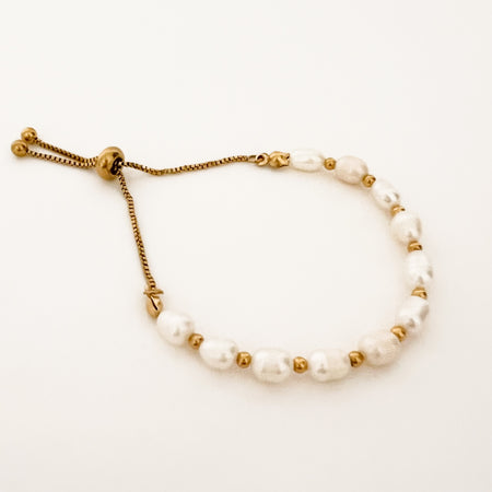 Ophelia Bracelet. Adjustable pearl and gold bracelet with pull chain adjuster. White pearls combined with gold plated balls make this a modern classic. Water, sweat and tarnish resistant. Made of hypoallergenic marine grade stainless steel, gold plated with special protective coating. Adjusts up to 8.5".