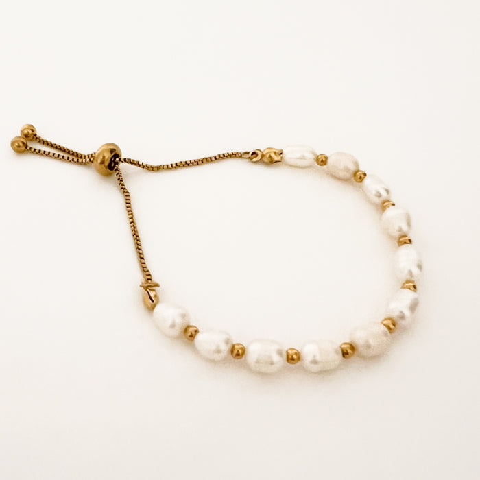 Ophelia Bracelet. Adjustable pearl and gold bracelet with pull chain adjuster. White pearls combined with gold plated balls make this a modern classic. Water, sweat and tarnish resistant. Made of hypoallergenic marine grade stainless steel, gold plated with special protective coating. Adjusts up to 8.5".