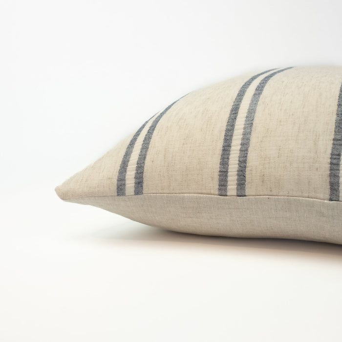 The Laguna Pillow is limited edition. Made from a handwoven hemp textile in a soft sand color with marine blue stripes. The perfect accent for any modern coastal home.  Measures 20” x 20”. Down insert included.