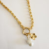 Gold plated chain necklace with a round hinged carabiner encrusted with clear pave' crystals holding a large white baroque pearl pendant and a golden poppy flower pendant. 26 inch length.