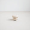 Pebble candle holder. Soft rounded ceramic shape inspired by beach pebbles  with a matte white glaze. Designed to hold the slim Wish Taper Candles (sold separately). 2.375" diameter x 1.75" tall.