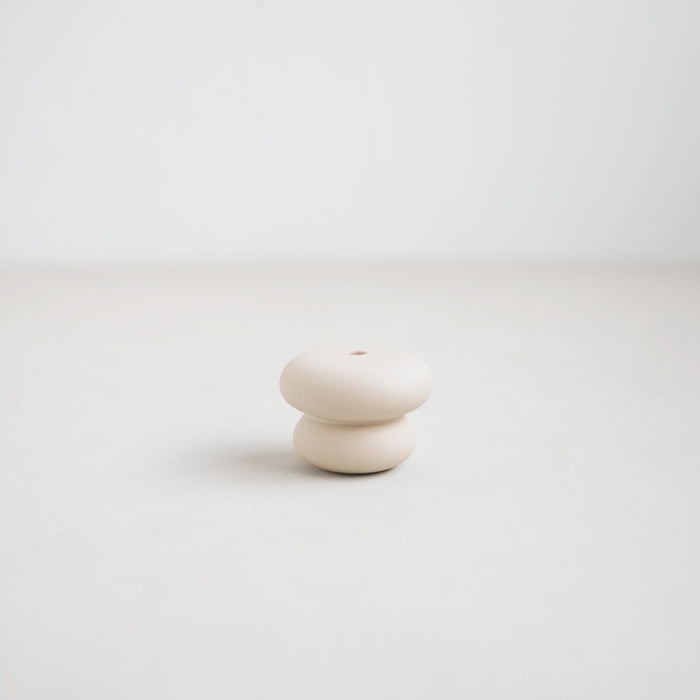 Pebble candle holder. Soft rounded ceramic shape inspired by beach pebbles  with a matte white glaze. Designed to hold the slim Wish Taper Candles (sold separately). 2.375" diameter x 1.75" tall.