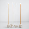 Collection of Pebbles slim taper candle holders. Modern and organic shapes in sand colored ceramic. Designed to fit the slim "Wishing Candles" shown styled in photo-sold separately. Each candle holder sold individually.