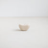 The Pod candle holder, part of the Pebbles collection designed to hold the slim Wish taper candles (sold separately). Organic ceramic form inspired by beach pebbles with a matte white glaze. 2.5" diameter x 1.25" tall.