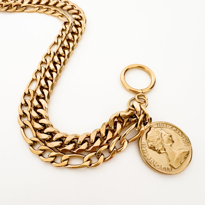 Rhodes double chain toggle bracelet with vintage inspired coin charm. Water, sweat and tarnish resistant jewelry. Made of gold plated marine grade stainless steel with protective coating. 7.5 inches.