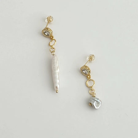 Pair of gold filled mis-matched earrings. Sparkling CZ studs, one adorned with a long white Baroque pearl drop, the other with a small white Biwa pearl drop.