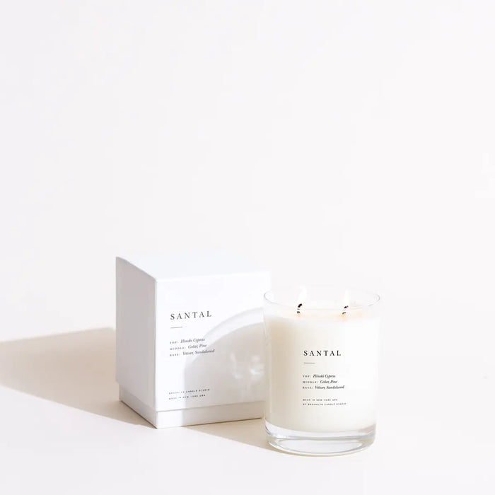 Santal scented candle with two wicks in clear glass vessel with modern + minimalist label. Ivory box.