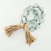 Decorative glass bead garland  in pale blue with natural jute tassels. 34 inch length. 1 inch glass beads.