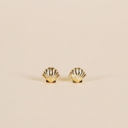 Pair of gold seashell stud earrings with delicate etched detailing. 18K gold plating over brass with protective coating to prevent tarnishing. Sterling silver posts. Hypoallergenic and Lead free. 6mm x 7mm