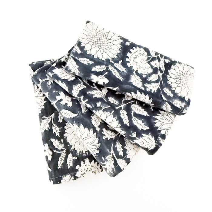 Set of 4 folded floral print napkins in a rich indigo and cream woodblock print. 18 inch square.